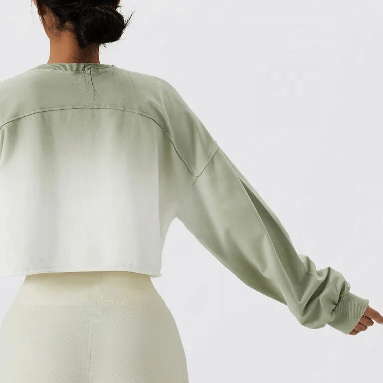 Back view of gradient color long-sleeve crop top in green and white, perfect for active women seeking style and comfort.